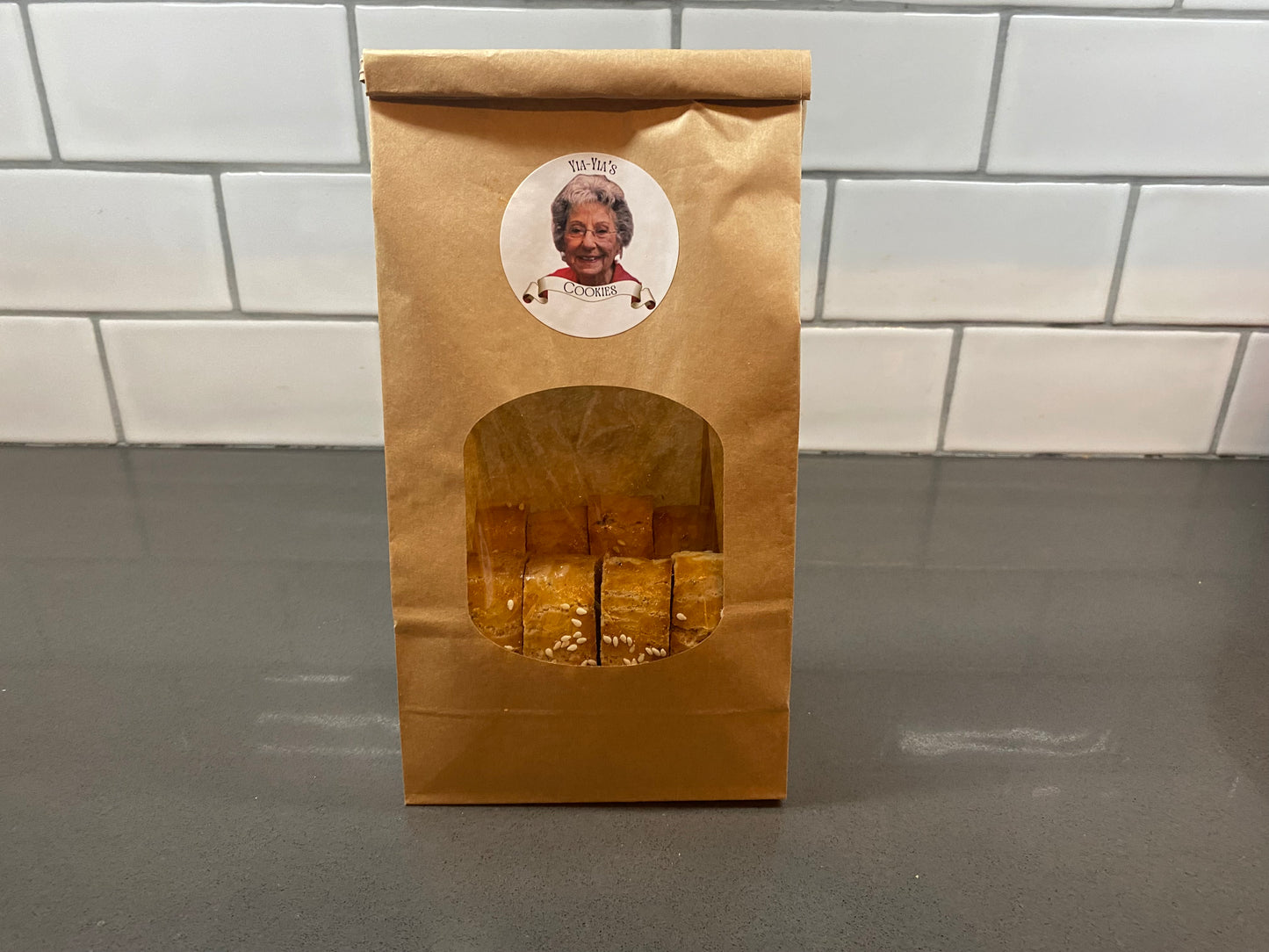 Brown paper bag with a window displaying cookies.