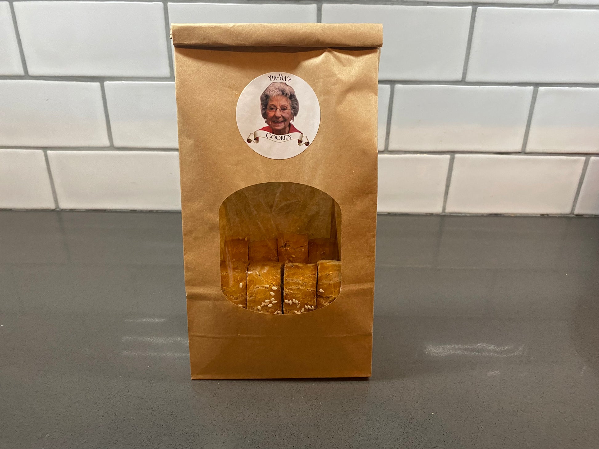 Brown paper bag with a window displaying cookies.